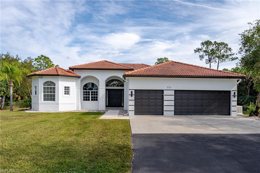 510 13th Street Northwest Naples, FL 34120 - Photo 1 of 50 a front view of a house with yard and garage