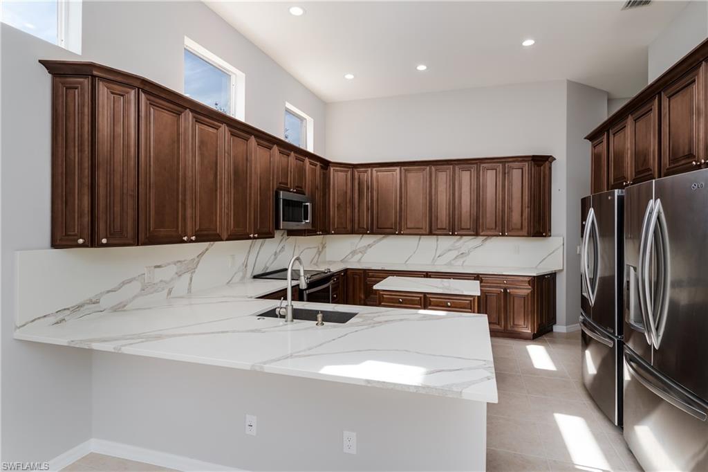 510 13th Street Northwest Naples, FL 34120 - Photo 22 of 50 a kitchen with stainless steel appliances granite countertop a sink refrigerator and cabinets