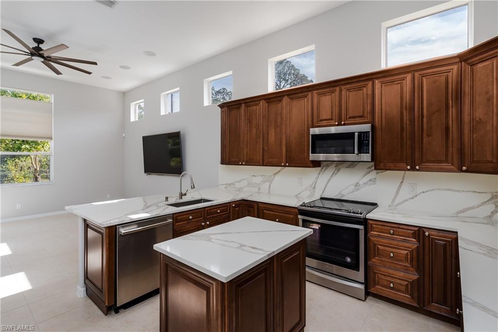510 13th Street Northwest Naples, FL 34120 - Photo 23 of 50 a kitchen with stainless steel appliances a stove microwave and sink
