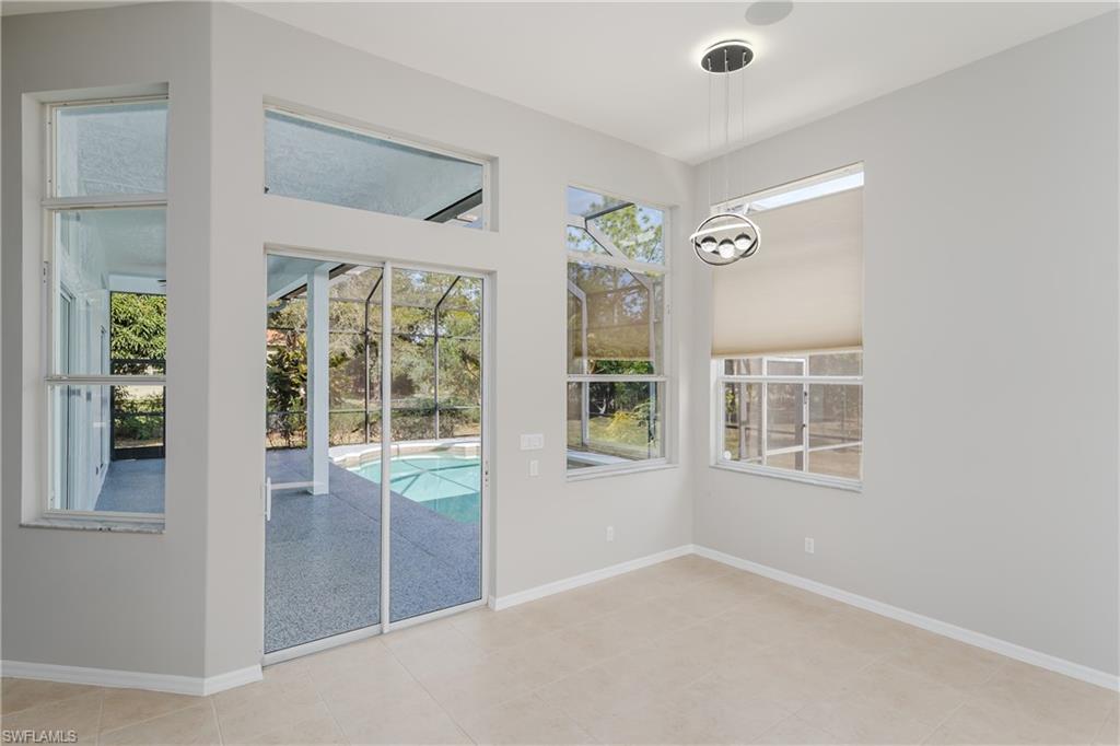 510 13th Street Northwest Naples, FL 34120 - Photo 27 of 50 an empty room with windows and chandelier