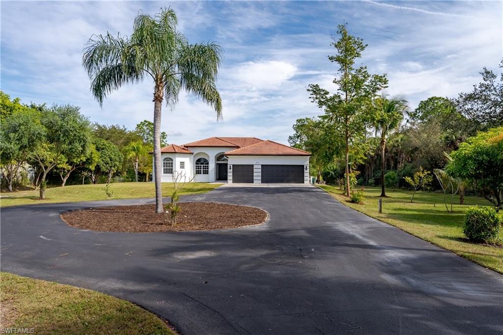 510 13th Street Northwest Naples, FL 34120 - Photo 3 of 50 a front view of a house with a yard and palm trees