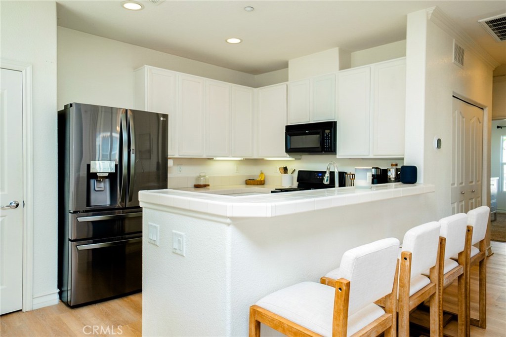 7331 Shelby Place, Unit 91 Rancho Cucamonga, CA 91739 - Photo 11 of 34 a kitchen with stainless steel appliances a refrigerator and a stove top oven