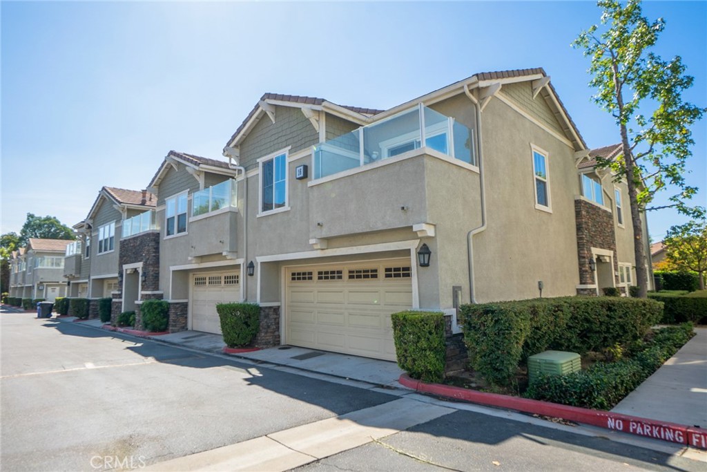 7331 Shelby Place, Unit 91 Rancho Cucamonga, CA 91739 - Photo 3 of 34 a front view of a house with a yard and garage