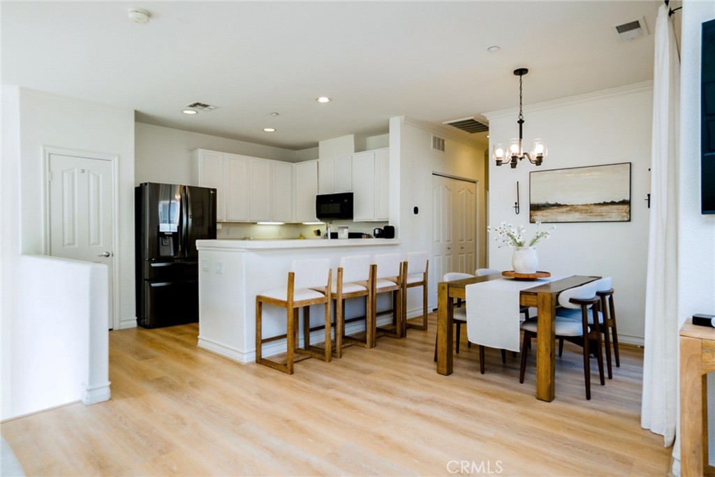 7331 Shelby Place, Unit 91 Rancho Cucamonga, CA 91739 - Photo 8 of 34 a kitchen with refrigerator a dining table and chairs