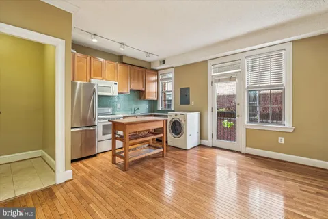 a kitchen with stainless steel appliances a refrigerator and wooden floor