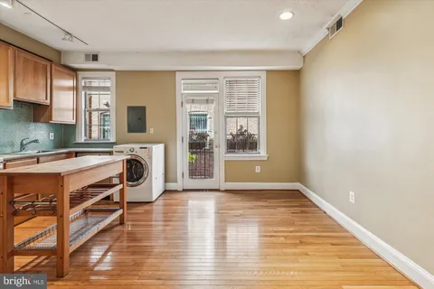 a view of a kitchen with workspace and wooden floor