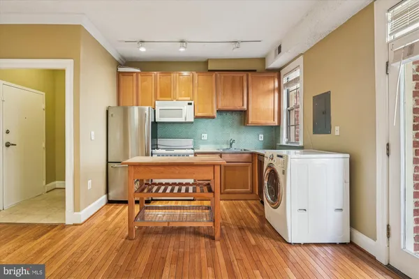 a kitchen with stainless steel appliances granite countertop a refrigerator a stove and a wooden floors