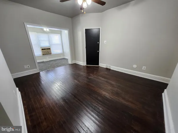 an empty room with wooden floor and mirror