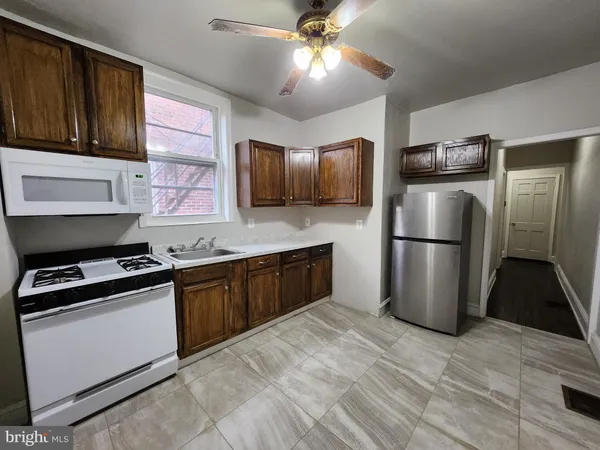 a kitchen with stainless steel appliances granite countertop a refrigerator a stove a sink and a microwave