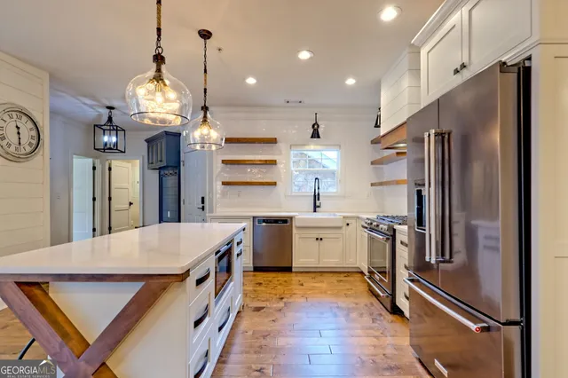 a kitchen with stainless steel appliances granite countertop a refrigerator a oven and a stove