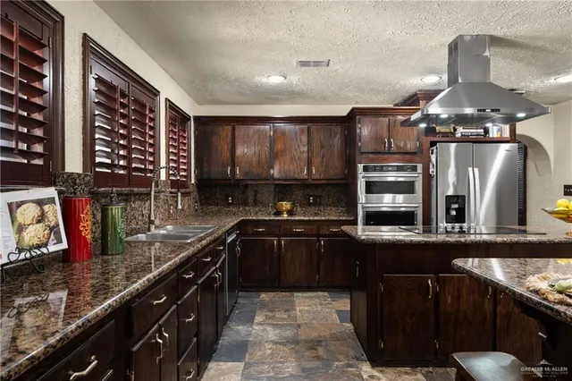 a kitchen with stainless steel appliances a sink stove and cabinets