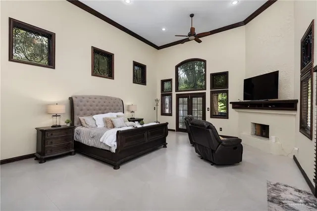 a spacious bedroom with a bed couch and a flat tv screen