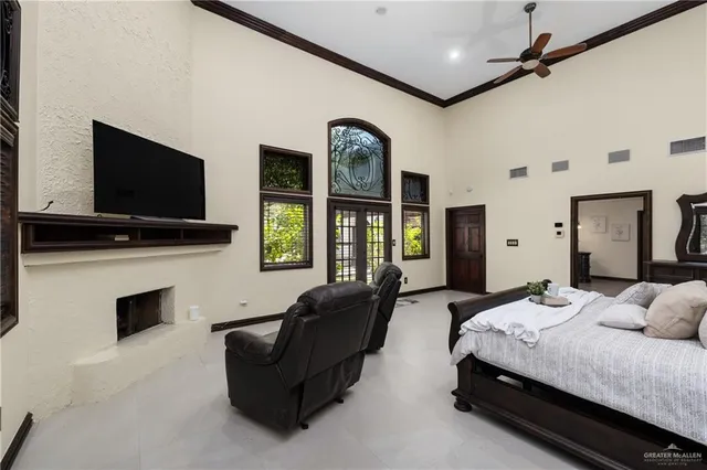 a spacious bedroom with a bed and a flat screen tv