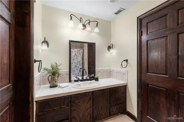 a bathroom with a granite countertop sink a mirror and vanity