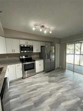 a view of a kitchen with electric appliances and cabinets