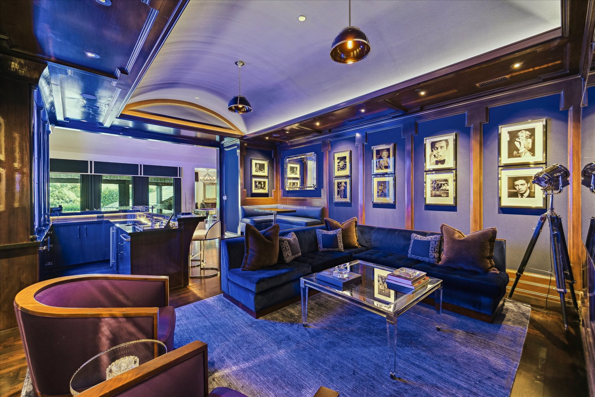 220 Merrie Way Lane Houston, TX 77024 - Photo 36 of 50 A dramatic media room featuring a color-lit barrel ceiling, custom oak millwork, wallpaper accents, pendant lighting, and a hidden A/V closet—all anchored by warm wide-plank oak floors.