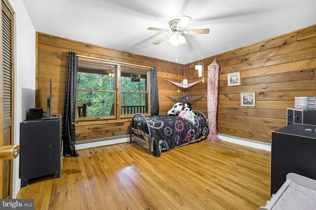 a spacious bedroom with a bed and wooden floor