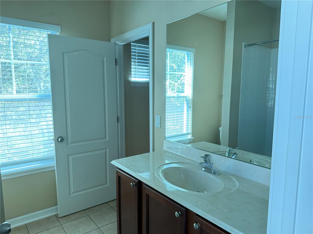 12910 Calderdale Avenue Windermere, FL 34786 - Photo 16 of 24 a bathroom with a granite countertop sink and a mirror