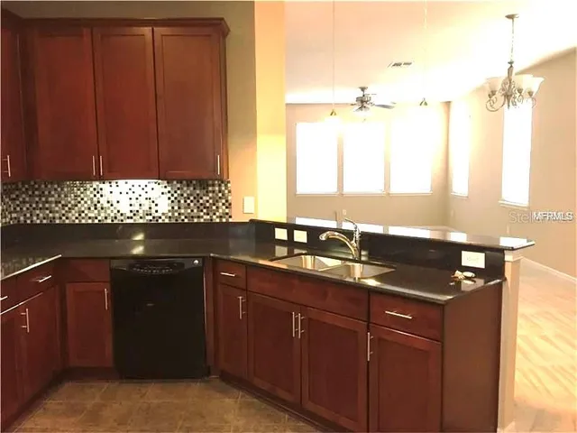 a kitchen with a sink a window and cabinets