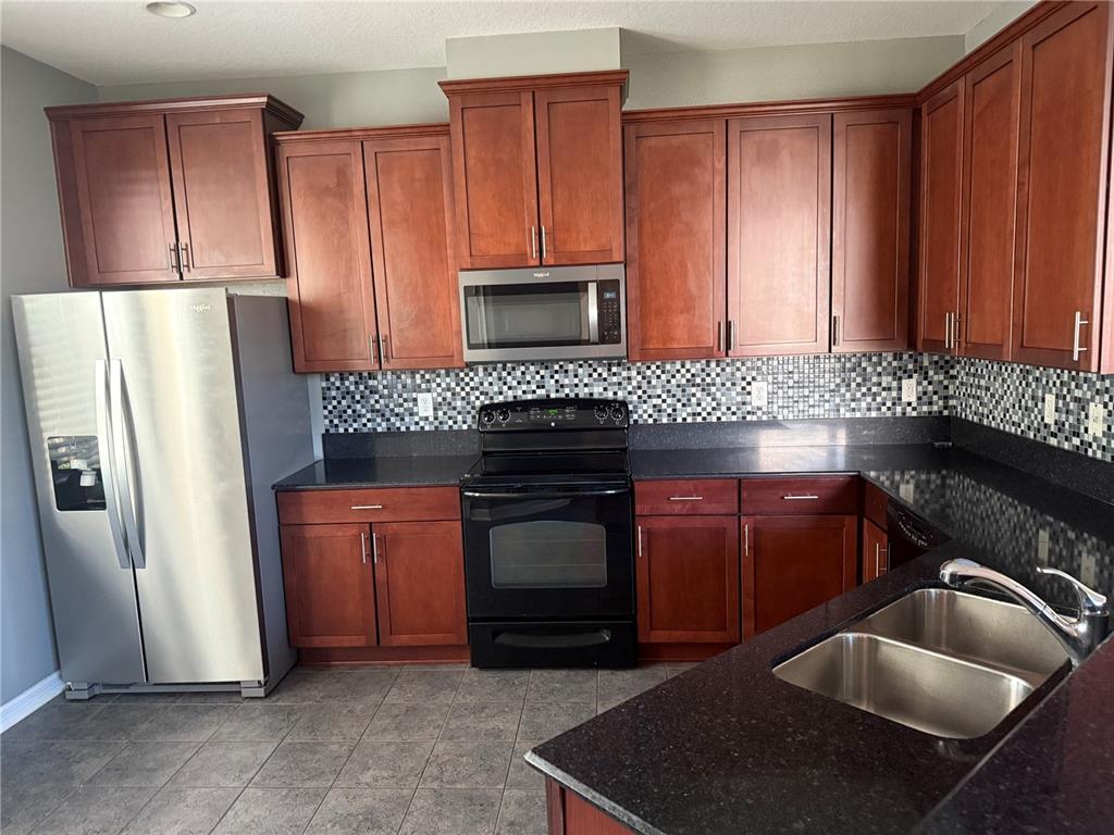 12910 Calderdale Avenue Windermere, FL 34786 - Photo 3 of 24 a kitchen with granite countertop a refrigerator stove and sink