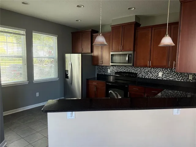 a kitchen with a refrigerator a sink and wooden cabinets