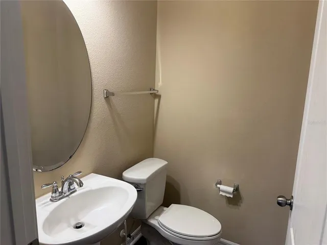 a bathroom with a sink mirror and toilet