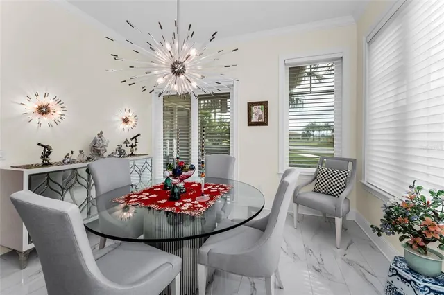 a kitchen with stainless steel appliances a white table chairs and a refrigerator