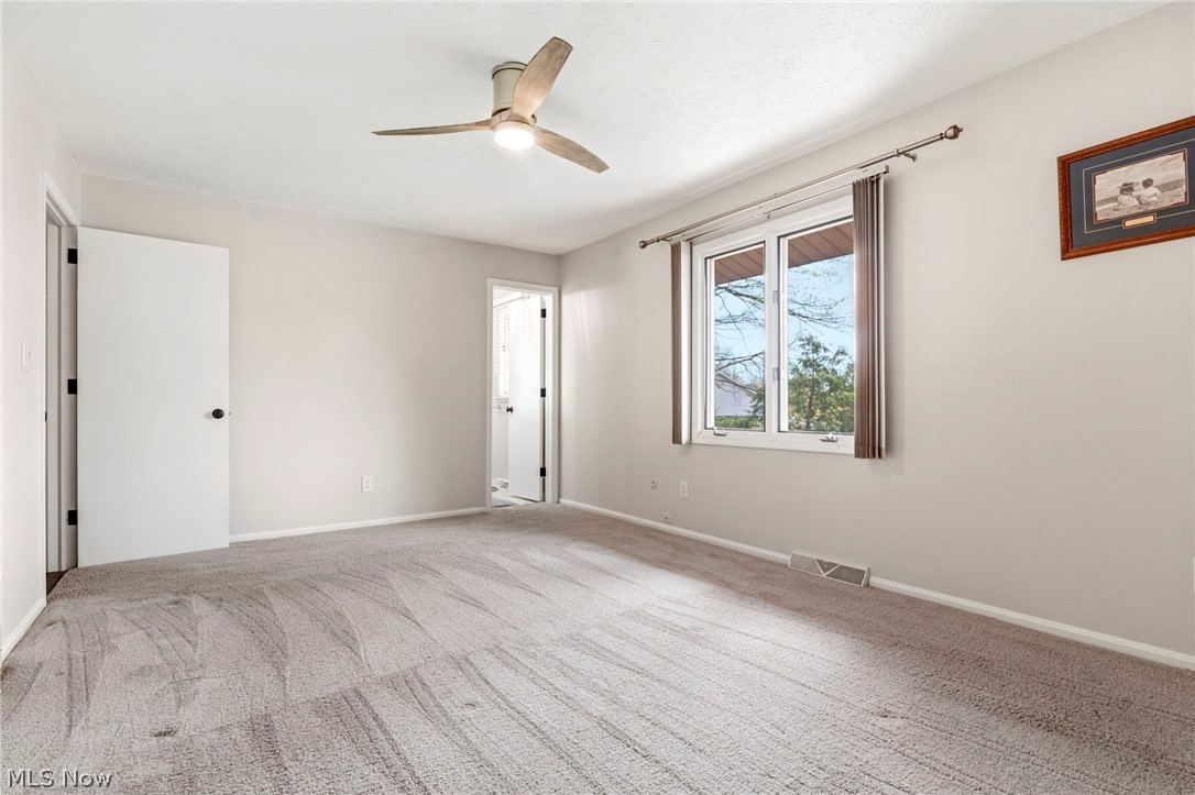 2400 Lancaster Road Akron, OH 44313 - Photo 18 of 41 Bright room with light gray carpeting, neutral-toned walls, and a ceiling fan