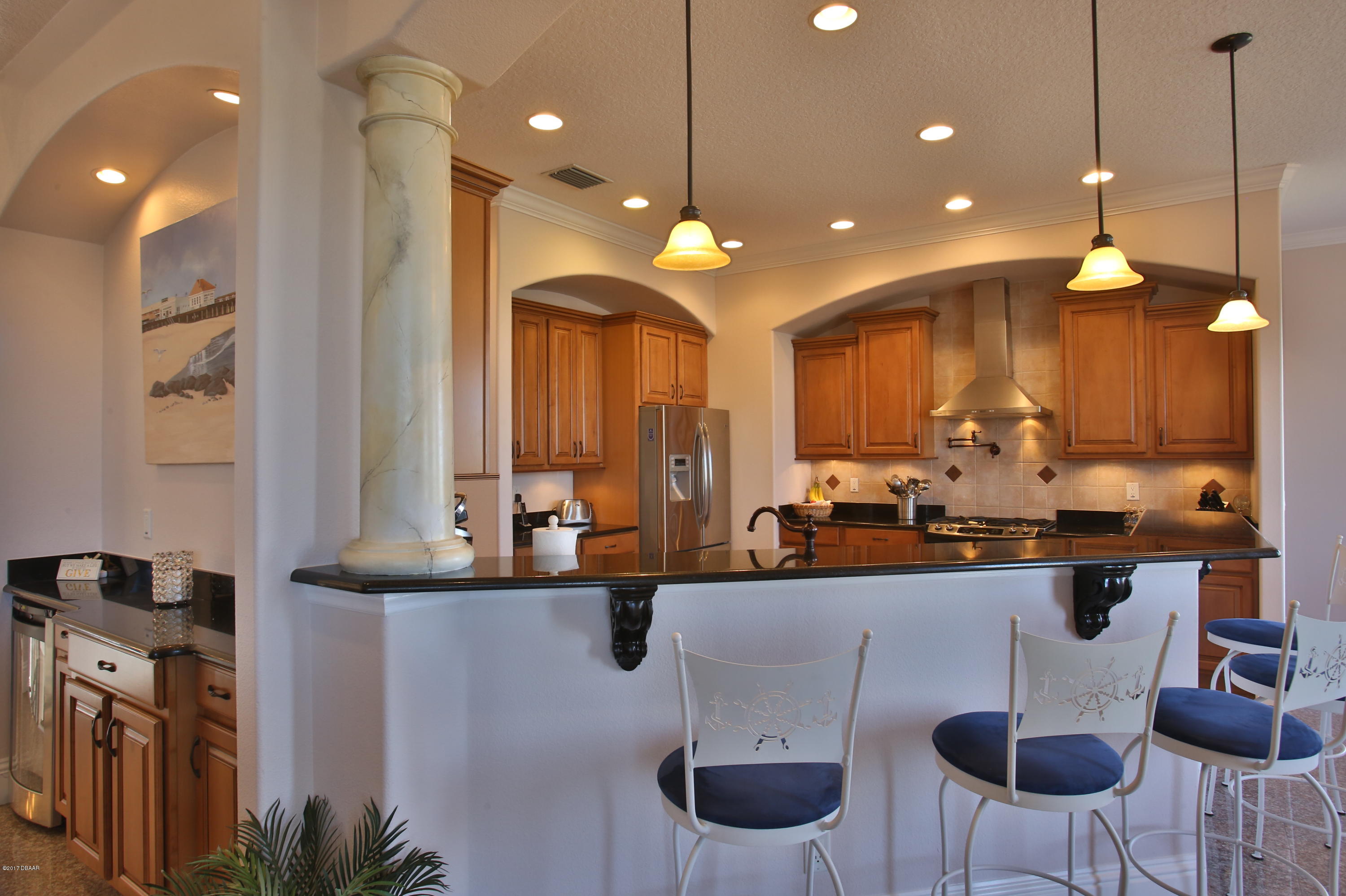 3 Mar Azul South Ponce Inlet, FL 32127 - Photo 9 of 36 a kitchen with a dining table chairs sink and white cabinets