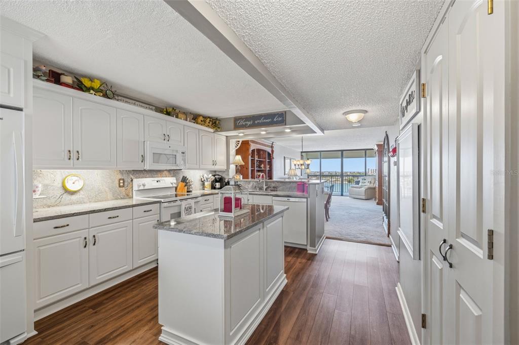 9425 Blind Pass Road, Unit 705 St. Pete Beach, FL 33706 - Photo 11 of 66 a kitchen with cabinets a sink and wooden floor
