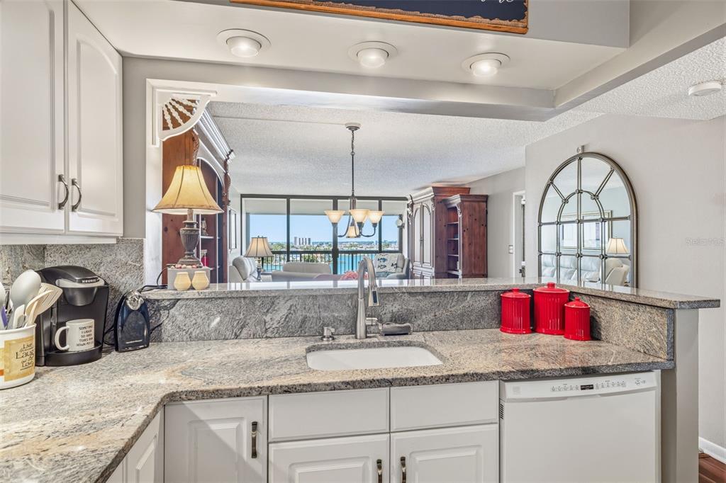 9425 Blind Pass Road, Unit 705 St. Pete Beach, FL 33706 - Photo 12 of 66 a kitchen with granite countertop cabinets and window