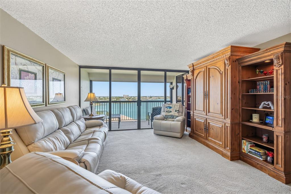 9425 Blind Pass Road, Unit 705 St. Pete Beach, FL 33706 - Photo 15 of 66 a living room with furniture and a floor to ceiling window
