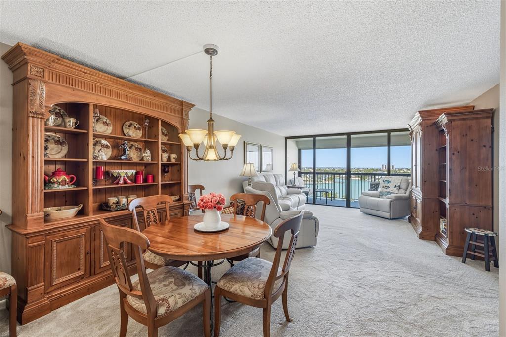 9425 Blind Pass Road, Unit 705 St. Pete Beach, FL 33706 - Photo 19 of 66 a view of a dining room and livingroom with furniture wooden floor and a window