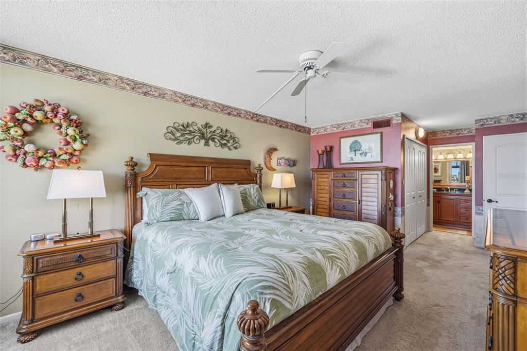 9425 Blind Pass Road, Unit 705 St. Pete Beach, FL 33706 - Photo 22 of 66 a bedroom with a bed and a chandelier