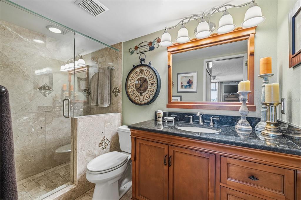 9425 Blind Pass Road, Unit 705 St. Pete Beach, FL 33706 - Photo 25 of 66 a bathroom with a toilet a sink and a mirror