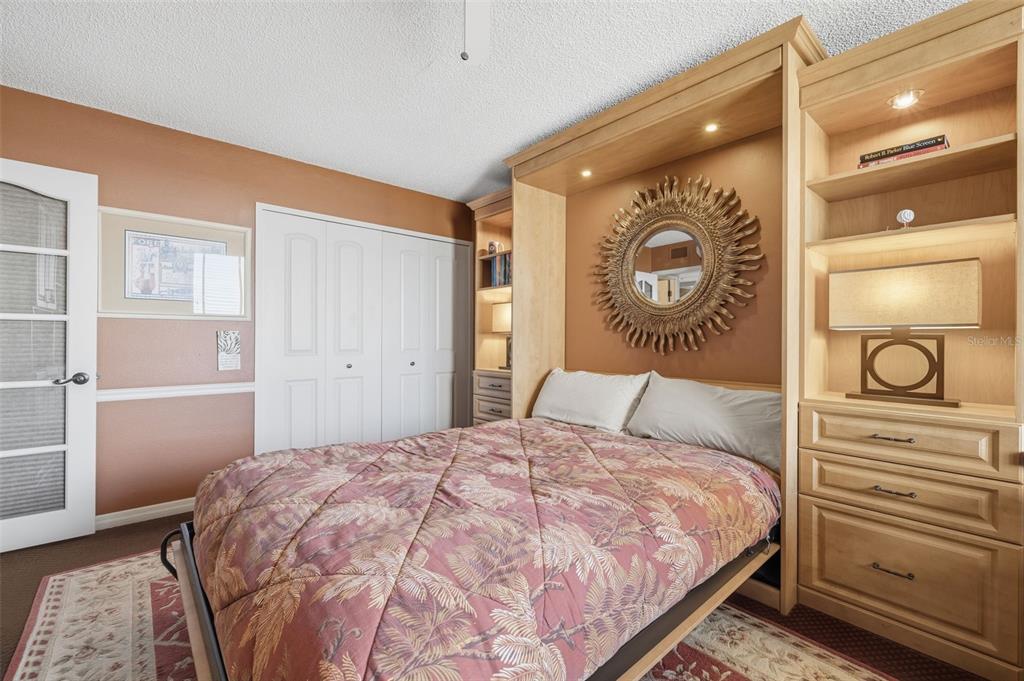 9425 Blind Pass Road, Unit 705 St. Pete Beach, FL 33706 - Photo 30 of 66 a bedroom with a bed and a closet
