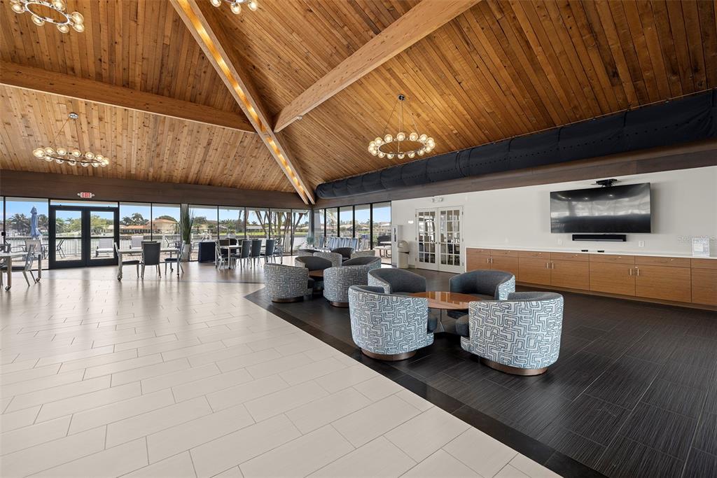 9425 Blind Pass Road, Unit 705 St. Pete Beach, FL 33706 - Photo 44 of 66 a lobby with furniture and flat screen tv