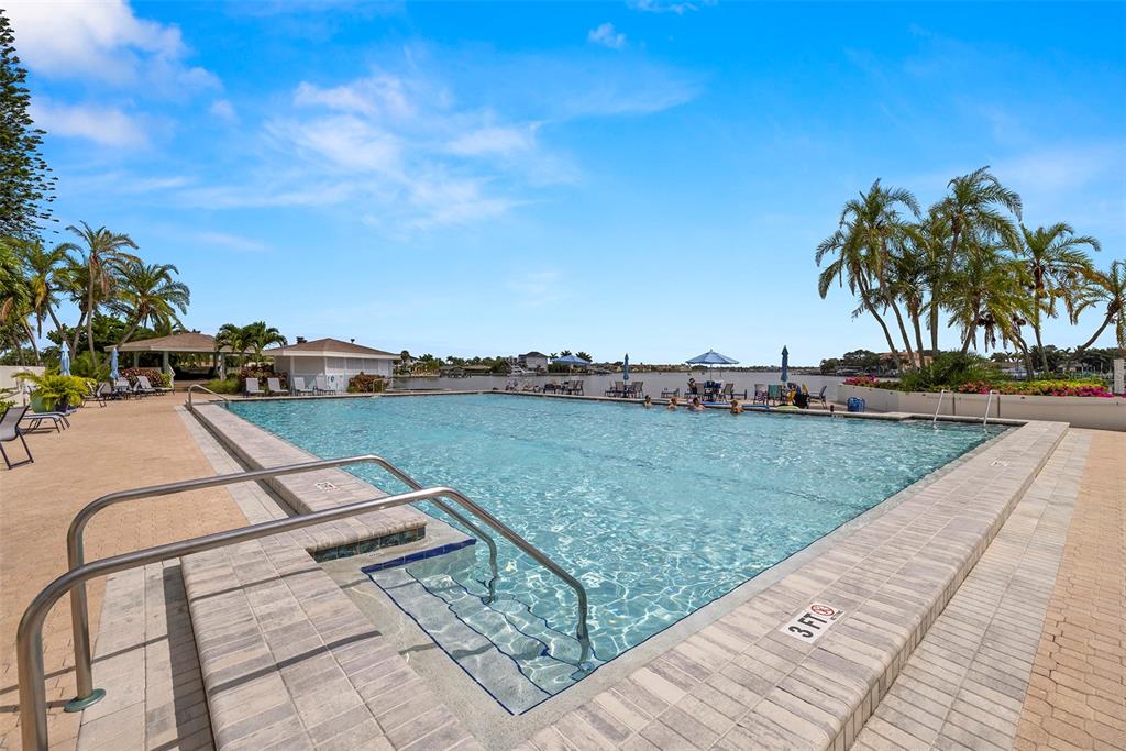 9425 Blind Pass Road, Unit 705 St. Pete Beach, FL 33706 - Photo 49 of 66 a view of swimming pool with a yard and sitting area