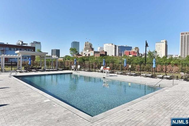 201 Dey Street, Unit 162 Harrison, NJ 07029 - Photo 15 of 21 a view of a swimming pool with outdoor seating and city view
