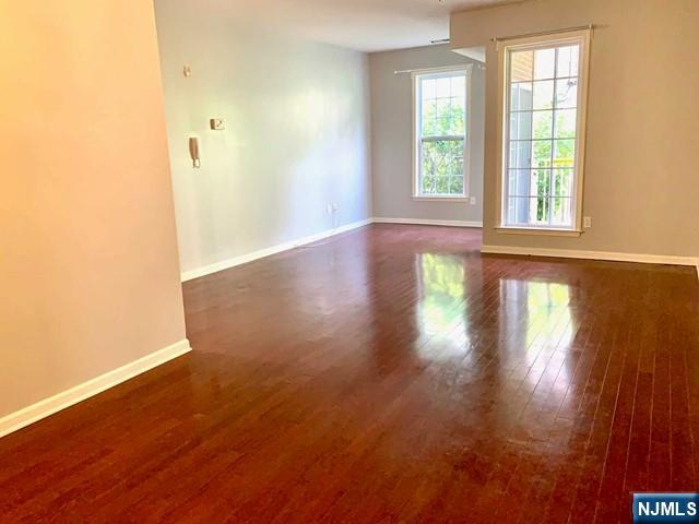 201 Dey Street, Unit 162 Harrison, NJ 07029 - Photo 2 of 21 an empty room with wooden floor and windows