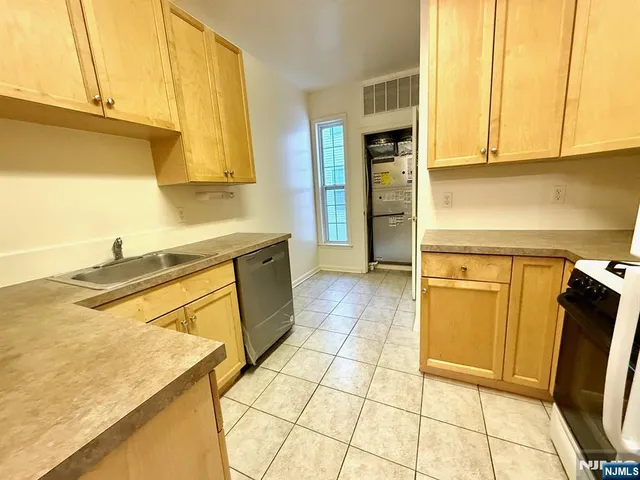a kitchen with granite countertop a sink a stove and cabinets