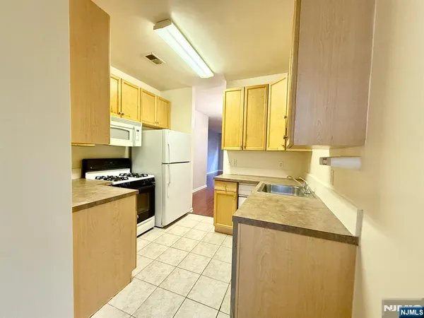 a kitchen with a refrigerator a stove a sink dishwasher and wooden cabinets