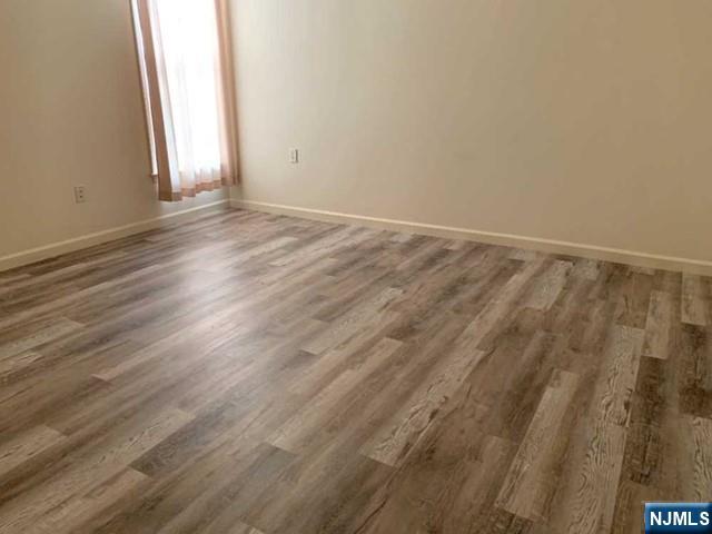 201 Dey Street, Unit 162 Harrison, NJ 07029 - Photo 7 of 21 a view of an empty room with wooden floor and a window