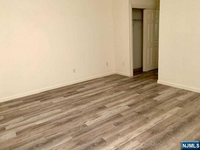 201 Dey Street, Unit 162 Harrison, NJ 07029 - Photo 9 of 21 a view of an empty room with wooden floor and a window