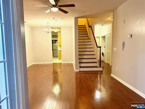 a view of a hallway with wooden floor and entryway