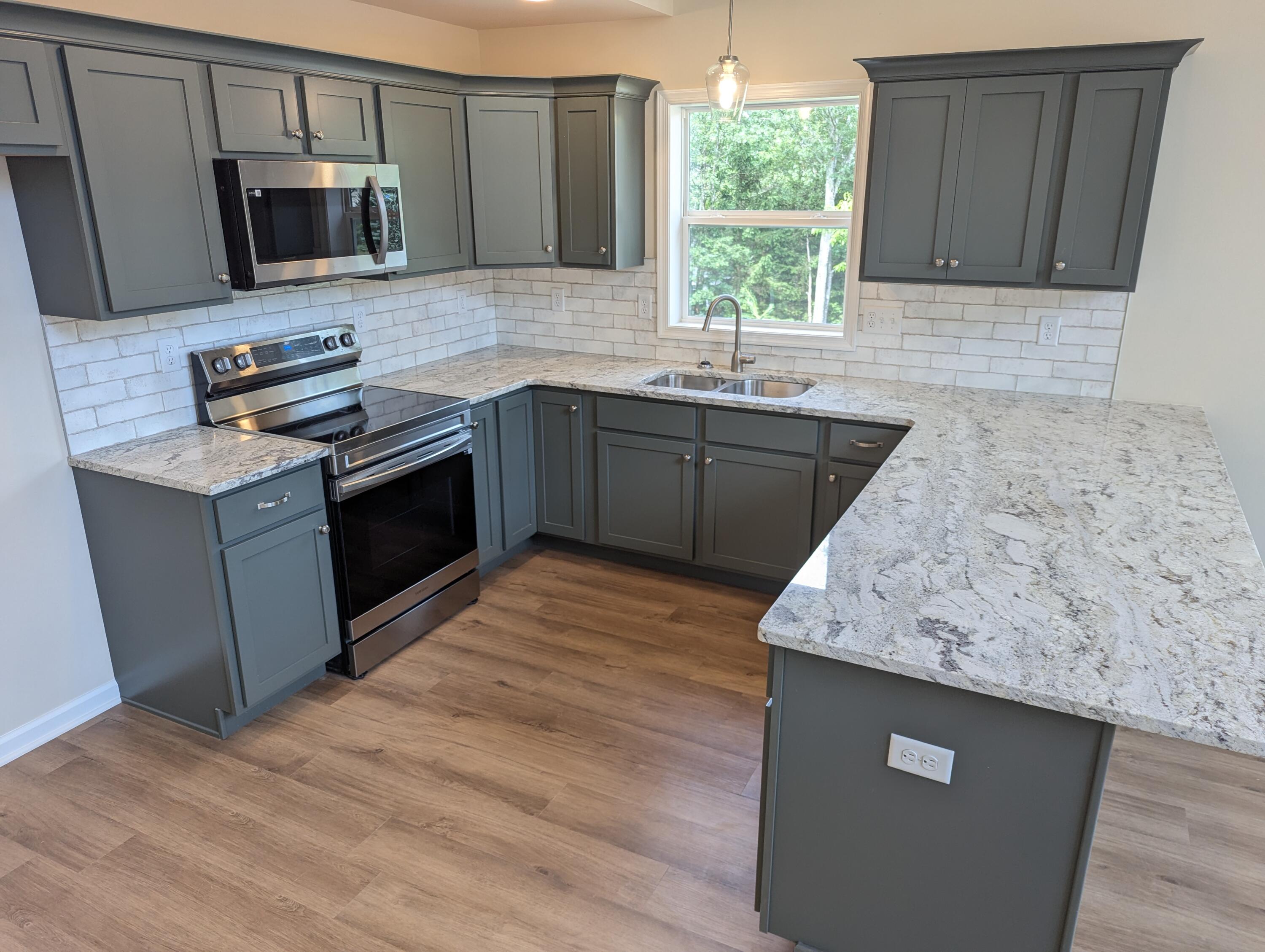 251 Bellingham Drive Bushkill, PA 18324 - Photo 5 of 53 a kitchen with stainless steel appliances granite countertop a sink stove microwave and refrigerator