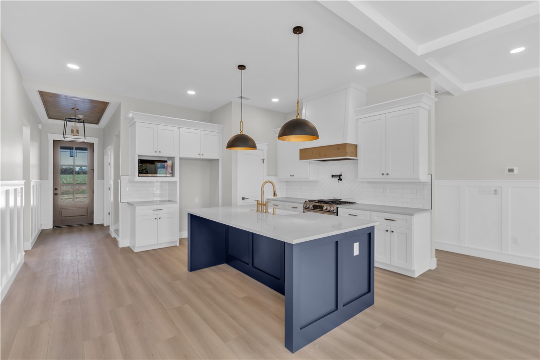 516 Lakeside Drive Anderson, SC 29621 - Photo 15 of 32 A contemporary kitchen features a spacious blue island, pendant lighting, and modern appliances, perfect for entertaining.