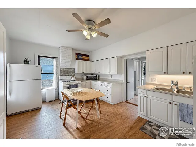 a kitchen with a refrigerator a sink dishwasher with a dining table and chairs