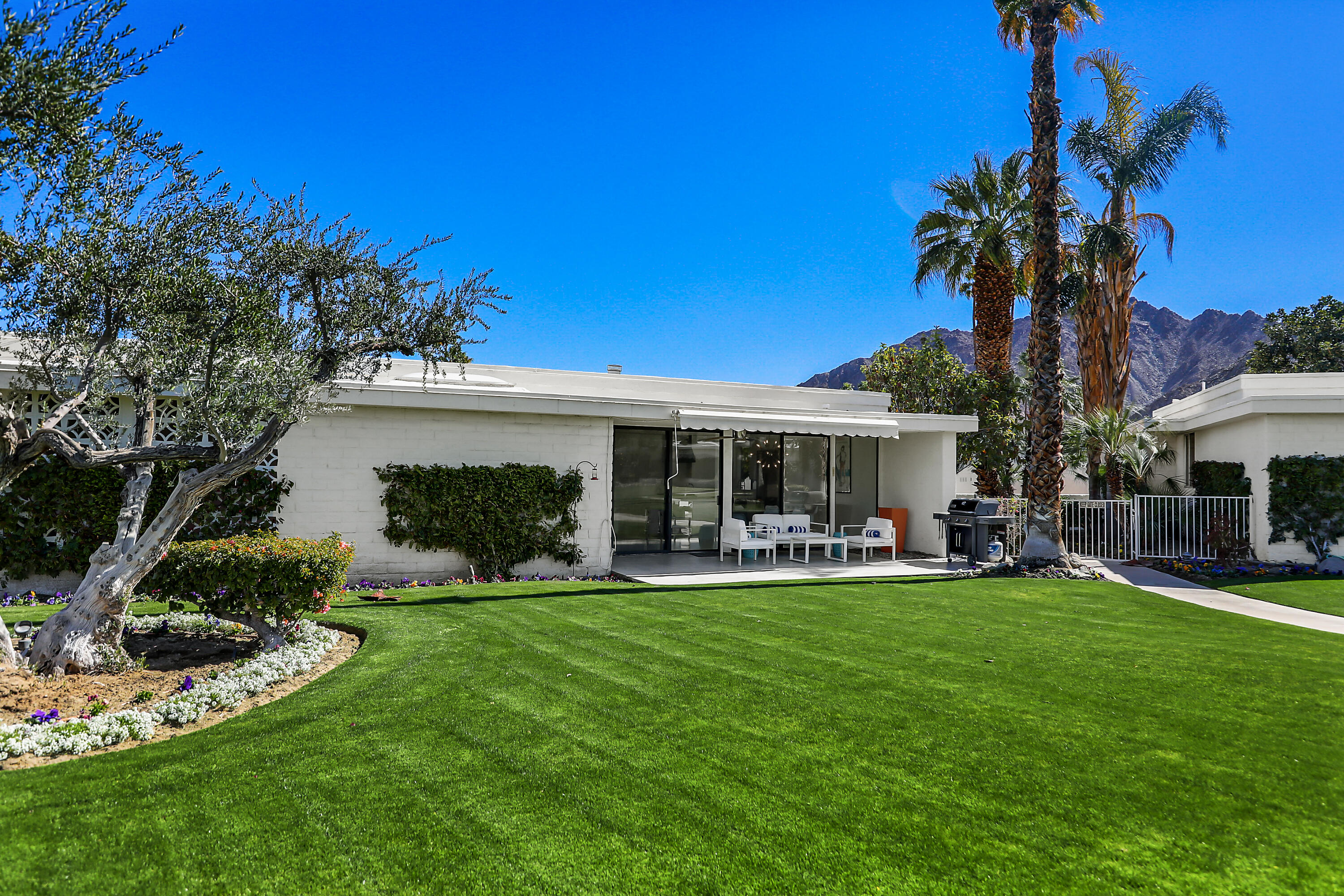 45765 Hopi Road Indian Wells, CA 92210 - Photo 15 of 39 a front view of a house with a garden and patio