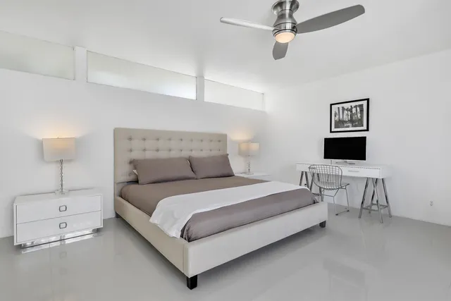 a bedroom with a bed tv and a large window